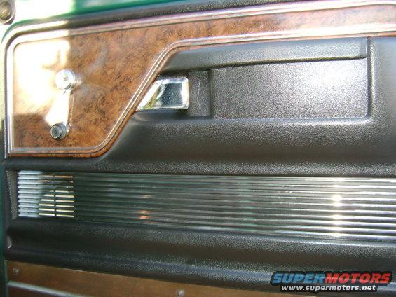 1979 Ford F-150 interior door panel with woodgrain trim, chrome handle, and speaker grille