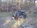 1984 Ford Bronco II - A modified off-road vehicle navigates a rocky, wooded path.