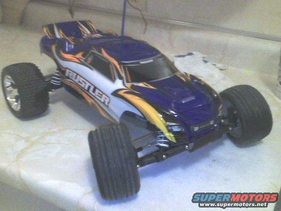 Blue and white remote control car with orange flames and 'RUSTLER' text