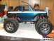 1996 Ford Bronco - This is a remote control monster truck with a teal and white body, large off-road tires, and chrome wheels.