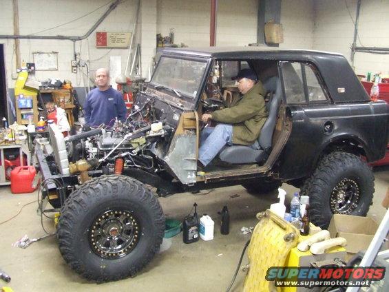 Black 1967 International Scout 800 with open doors and exposed engine in a workshop
