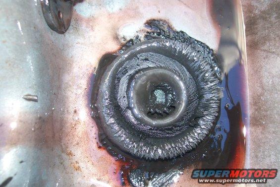 Worn transmission drain plug with metal shavings and dark fluid