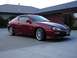 1993 Mazda MX-3 - This red coupe is parked in a driveway in front of a house.