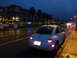 2003 Volkswagen Beetle - A white Volkswagen Beetle is parked on a wet street as dusk settles, with apartment buildings visible in the background.