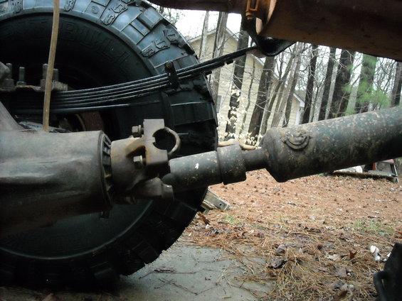 Close-up of a driveshaft and U-joint connected to a rear axle and leaf spring suspension