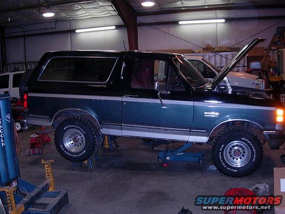 1989 Ford Bronco in garage with hood up, on jack stands