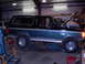 1989 Ford Bronco - This two-tone Ford Bronco is in a garage, possibly undergoing maintenance or repairs.