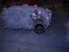 1989 Ford Bronco - A gray metal transfer case with a splined output shaft and an electrical connector is shown.