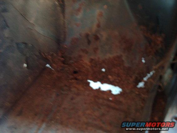 Rusted metal panel with white specks and Supermotors.net watermark