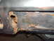 1978 Ford Mustang II - Detail of significant rust and corrosion on a vehicle's metal panel, showing deterioration.