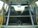 1983 Volkswagen Rabbit - The interior of a car is shown with a prominent roll cage and black bucket seats.
