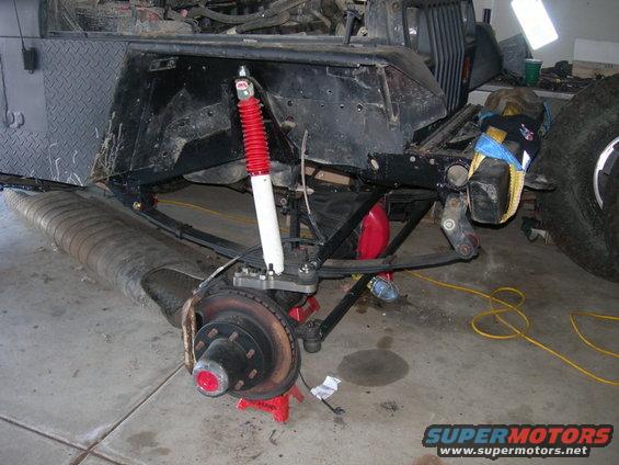 Jeep Wrangler front suspension with red shock absorber and large tire