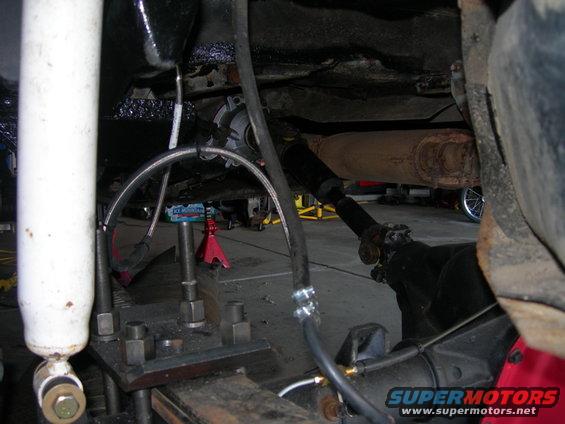 Underside of a vehicle showing suspension, driveshaft, and exhaust