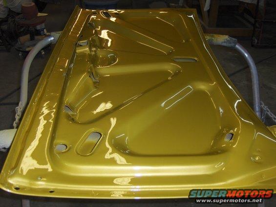 Interior of a yellow car door, showing bracing and mounting holes