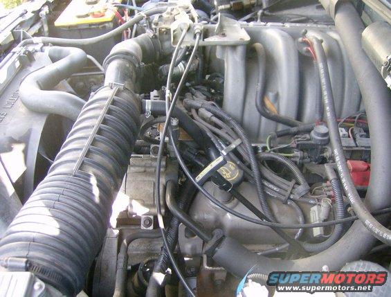 Engine bay of a 1994 Ford Bronco, showing intake manifold, fan, and wiring