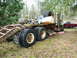 1981 Kenworth W900A - A weathered semi-truck trailer and cab sit parked in a grassy area with a red pickup truck nearby.