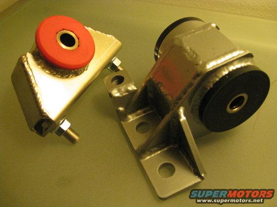 Two aftermarket engine mounts, one with a red bushing, the other with a black bushing