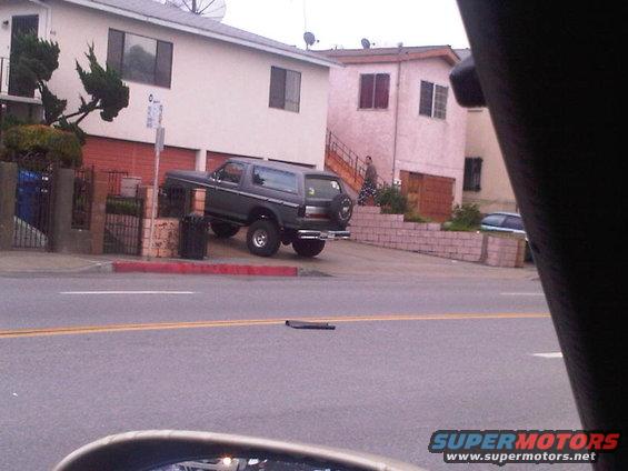 Dark gray SUV parked on a steep incline, spare tire on rear door