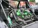 1986 Ford Bronco - A modified truck's interior shows a large radiator with green fans, a fire extinguisher, and a roll cage, with other vehicles visible outsi…