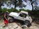 1973 Ford Bronco - Jeep Wrangler navigating a challenging off-road course with rocky terrain and trees.