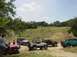 1973 Ford Bronco - A group of off-road vehicles gathered in a scenic, open landscape under a partly cloudy sky.