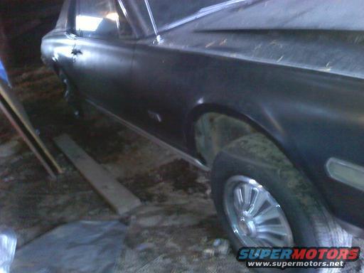 dark colored car, side view, in a garage or shed