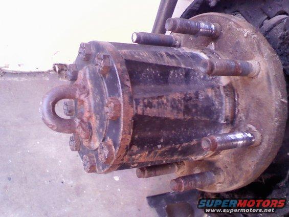 Rusted hub assembly with six lug bolts and a tow hook attachment