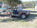 1978 Ford F-250 - This weathered Ford Bronco, likely from the late 1970s, sits in a yard with a boat on a trailer nearby.