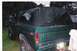 1979 Ford Bronco - Rear view of a green Ford Bronco with a black soft top and off-road tires.