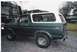 1979 Ford Bronco - Side profile of a green and white 1979 Ford Bronco parked on a gravel surface.