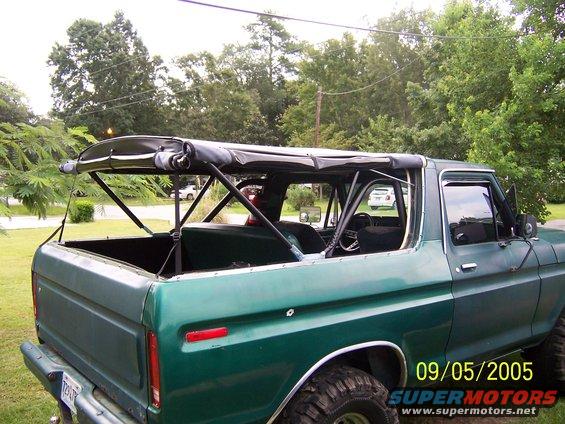 Green 1979 Ford Bronco with soft top removed, rear quarter view