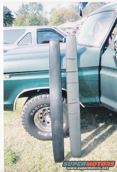 Two trim pieces, one dark gray and one lighter gray with cracks, are placed in front of a green 1978 Ford Bronco. Another vehicle is visible behind the Bronco