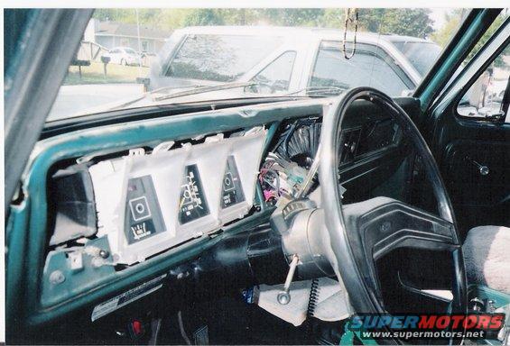 Dashboard with gauges removed, showing wiring. Steering wheel visible