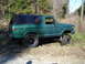 1979 Ford Bronco - This 1979 Ford Bronco features a green exterior, a black soft top, and a lifted suspension, viewed from the side.