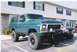 1979 Ford Bronco - This lifted green 1979 Ford Bronco features a prominent grille and is parked alongside another vehicle.
