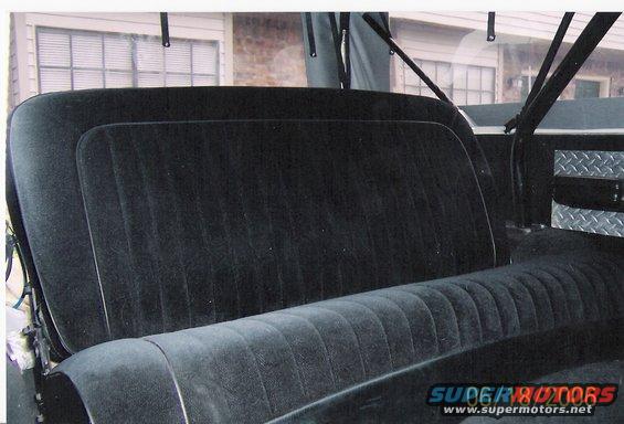 Back seat and interior of a vehicle, with diamond plate trim visible on the right