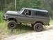 1979 Ford Bronco - This lifted 1978 Ford Bronco is shown from a three-quarter front angle on a dirt road surrounded by trees.