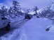 1986 Ford Bronco - Multiple vehicles navigate a snow-covered mountain pass, with a white Ford truck leading the way.