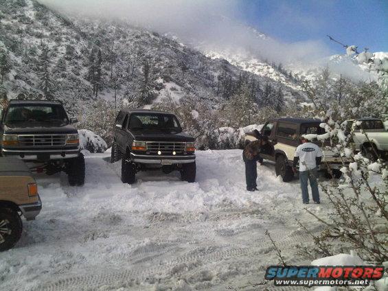 Black Ford Bronco with lifted suspension and aftermarket lights in the snow