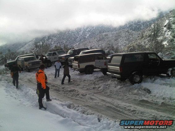 Several Ford Broncos and trucks stuck in snow on a mountain road