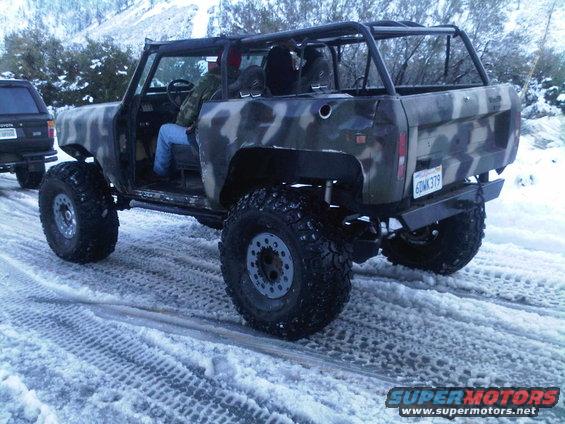 Camouflaged off-road vehicle with large tires on a snowy road