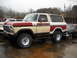 1982 Ford Bronco - This two-tone Ford Bronco is parked next to another vehicle in an outdoor lot.