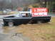 1982 Ford Bronco - A vintage Ford Ranchero sits abandoned with its hood open, adorned by a vintage auto parts sign.