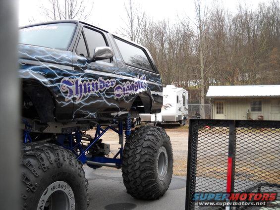 Black lifted Ford Bronco with lightning graphics and "Thunder Beast" text, seen from the side