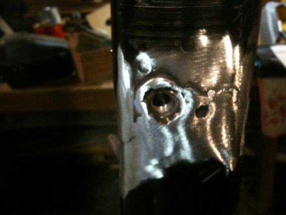Close-up of a metal part with a hole and some rough edges