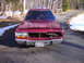 1988 Ford Crown Victoria LTD - A red station wagon sits on a paved surface with snow on the sides of the road. The front of the vehicle is damaged.