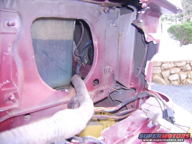 Red car fender damage, exposed wiring, and fluid reservoir