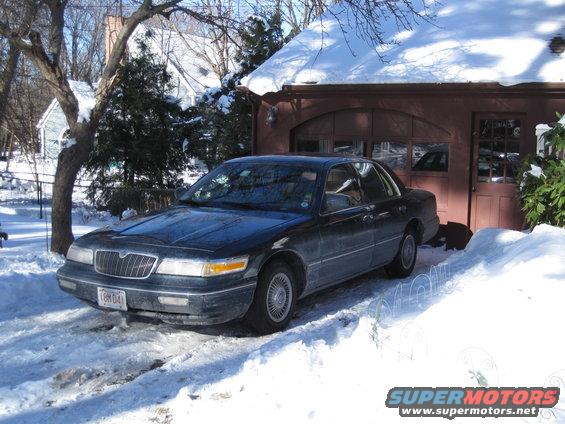 Dark sedan parked in snow, front quarter view. License plate 1BMD41