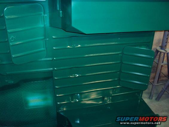 Interior of a green vehicle showing ribbed panels and floor. "SUPERMOTORS www.supermotors.net" text is visible