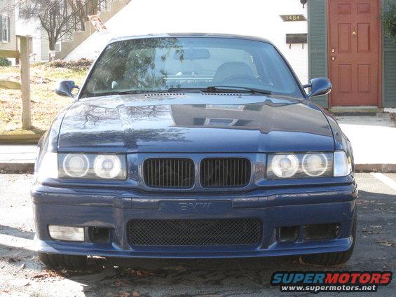 Front view of a dark blue BMW sedan parked in front of a house